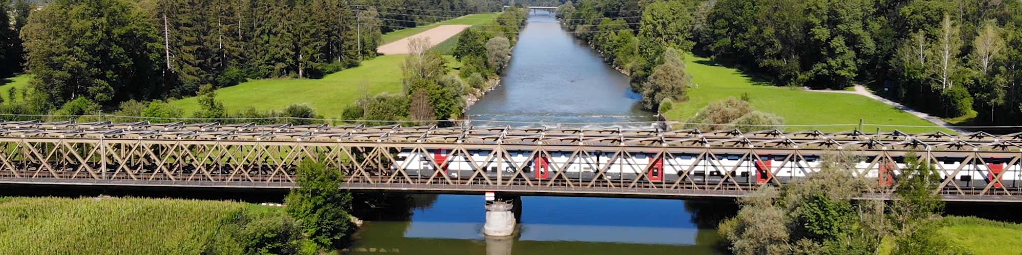 Intercity-Zug der SBB fährt über eine Brücke über den Fluss Thur